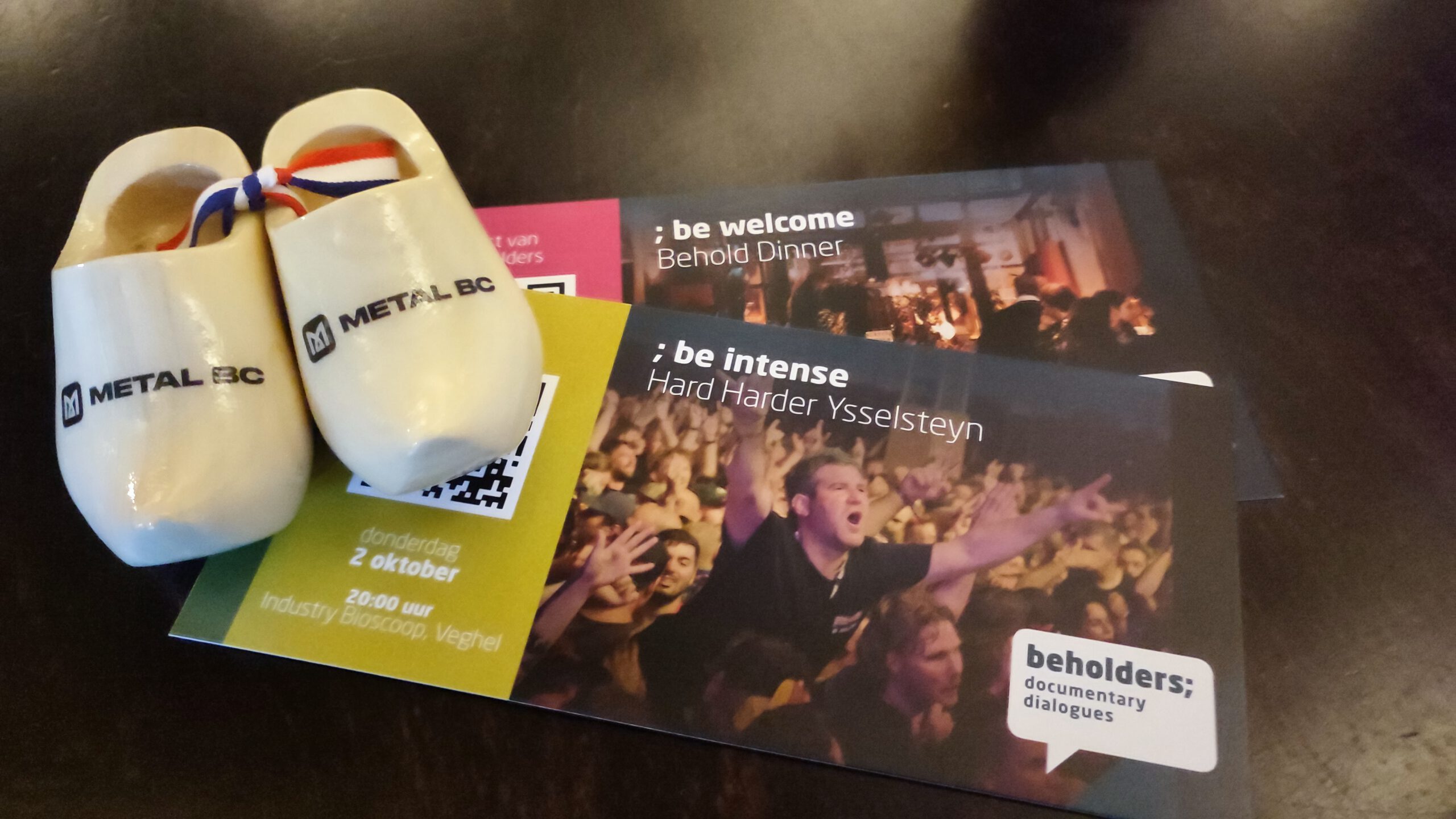 Traditionelle, niederländischer Holzschuhe mit BC-Logo und Eintrittskarten auf einem Tisch.