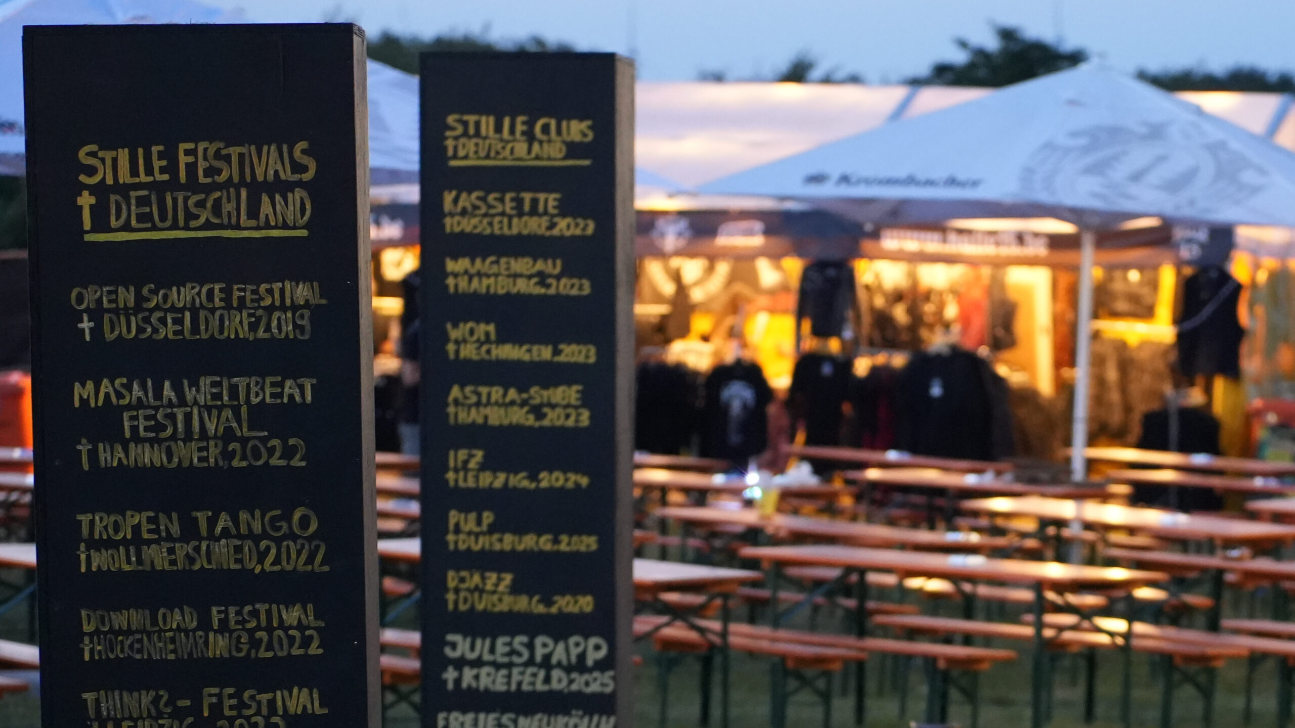 Kunstaktion auf dem DONG Open Air 2025: Stelengräber mit gestorbenen Festivals als Inschrift.