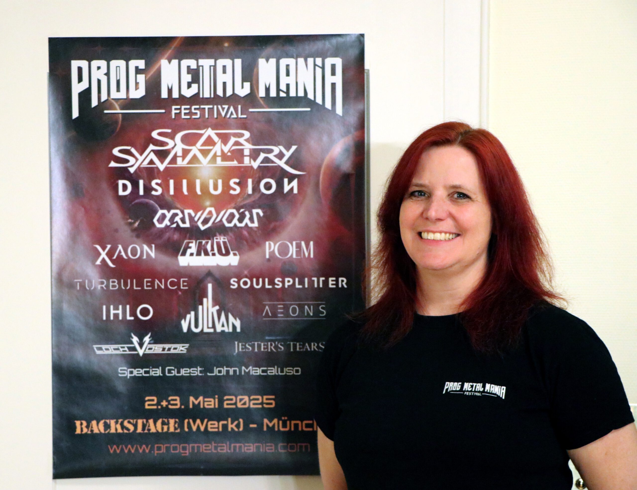 Eine Frau steht neben einem Roll-Up des Prog Metal Mania Festivals.